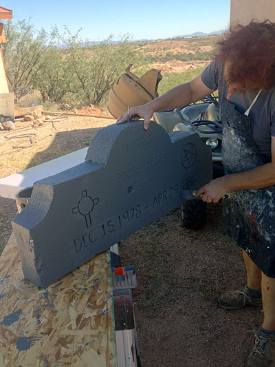 Roderick works on a headstone.